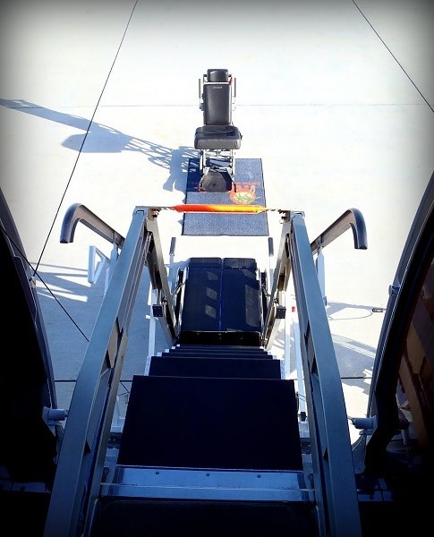 Passenger being transferred aboard a private jet using a boarding lift